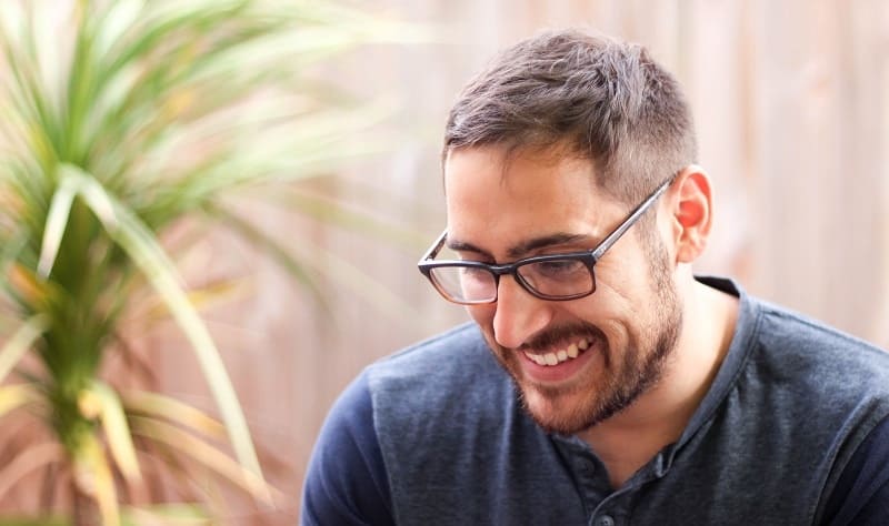 A happy, smiley man is thinking about how a video agency is creating some great video content for him.